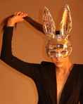 Заредете изображението в програмата за преглед на галерия, Person wearing a silver sequin bunny mask against a warm-toned background
